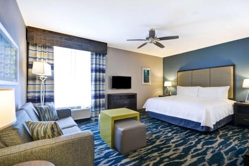 a hotel room with a bed and a couch at Homewood Suites by Hilton Conroe in Conroe