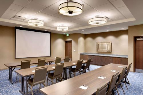 a conference room with tables and chairs and a screen at Hampton Inn & Suites Rexburg in Rexburg