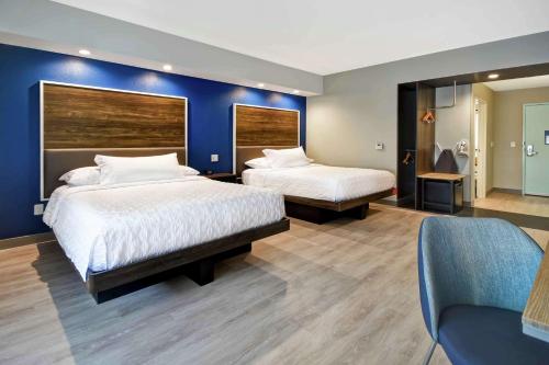 - une chambre avec 2 lits et un mur bleu dans l'établissement Tru By Hilton North Platte, à North Platte