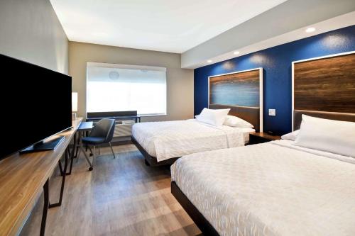 a hotel room with two beds and a flat screen tv at Tru By Hilton North Platte in North Platte