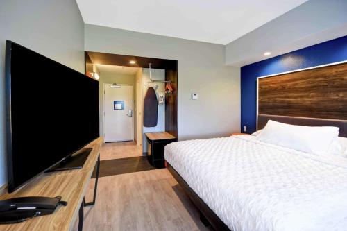 a hotel room with a bed and a flat screen tv at Tru By Hilton North Platte in North Platte