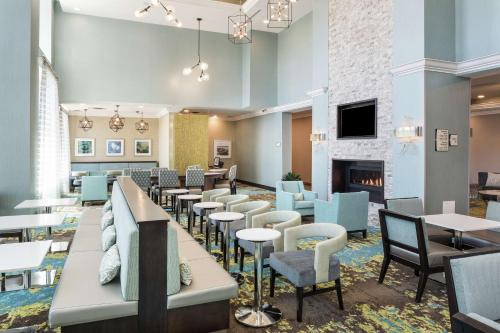 a restaurant with tables and chairs and a fireplace at Homewood Suites By Hilton Ottawa Airport in Ottawa