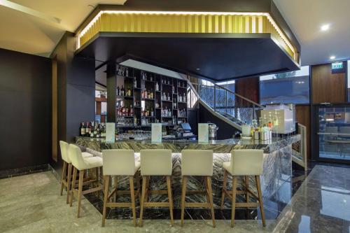 a bar with white chairs and a staircase at Hilton Garden Inn Yalova in Yalova
