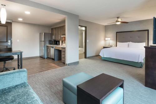 a hotel room with a bed and a kitchen at Homewood Suites By Hilton Ottawa Airport in Ottawa