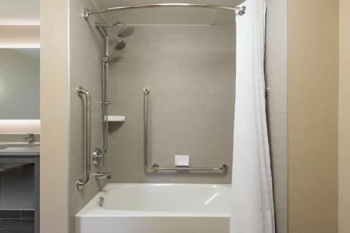 a bathroom with a shower and a white tub at Homewood Suites By Hilton Ottawa Airport in Ottawa