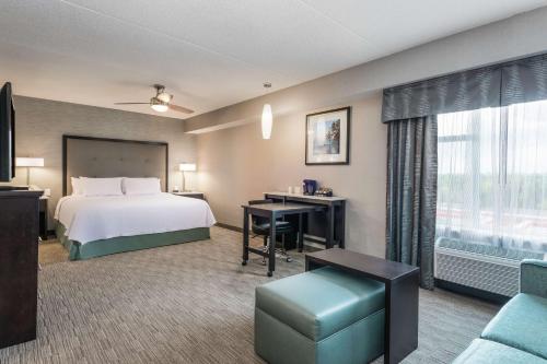 a hotel room with a bed and a desk at Homewood Suites By Hilton Ottawa Airport in Ottawa