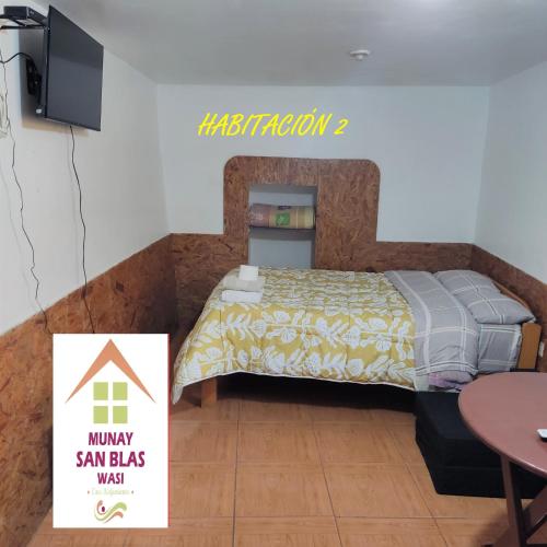 1 dormitorio con 1 cama, TV y mesa en Munay San Blas Wasi, en Cusco