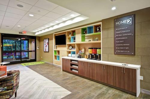 a lobby of a pharmacy with a sign on the wall at Home2 Suites Mechanicsburg in Mechanicsburg