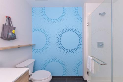 a bathroom with a shower with blue dots on the wall at Tru By Hilton Little Rock West in Little Rock