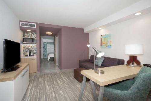 a living room with a couch and a desk in a room at Hilton Garden Inn Omaha Aksarben Village in Omaha