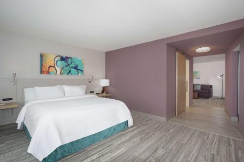 a bedroom with a large bed and a living room at Hilton Garden Inn Omaha Aksarben Village in Omaha