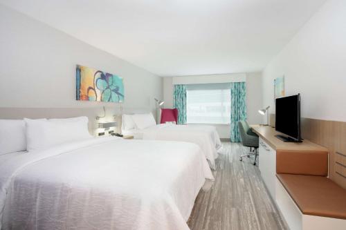 um quarto de hotel com duas camas e uma televisão de ecrã plano em Hilton Garden Inn Omaha Aksarben Village em Omaha