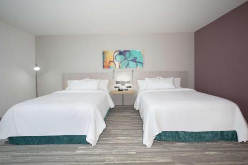 two beds in a hotel room with white sheets at Hilton Garden Inn Omaha Aksarben Village in Omaha