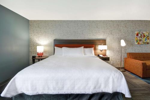 a bedroom with a large white bed and a couch at Home2 Suites By Hilton Texas City Houston in Texas City