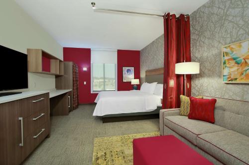 莫比尔Home2 Suites by Hilton Mobile International Airport的配有床和沙发的酒店房间