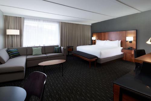 a hotel room with a bed and a couch at Doubletree By Hilton Montreal Airport in Dorval