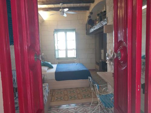 a small bedroom with a bed and a window at The 1930's Maltese Residence in St Paul's Bay