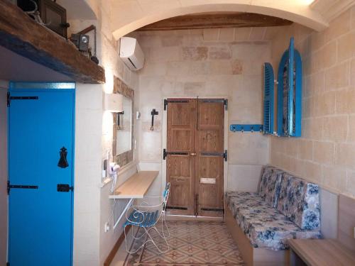 a small room with a blue door and a couch at The 1930's Maltese Residence in St. Paul's Bay