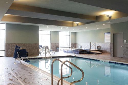 a large swimming pool with a gym in a building at Hilton Garden Inn Madison Sun Prairie in Sun Prairie