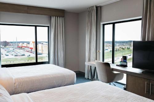 a hotel room with two beds and a desk with a television at Hilton Garden Inn Madison Sun Prairie in Sun Prairie