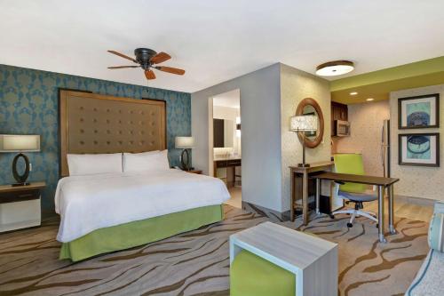 薩凡納的住宿－Homewood Suites By Hilton Savannah Airport，配有一张床和一张书桌的酒店客房