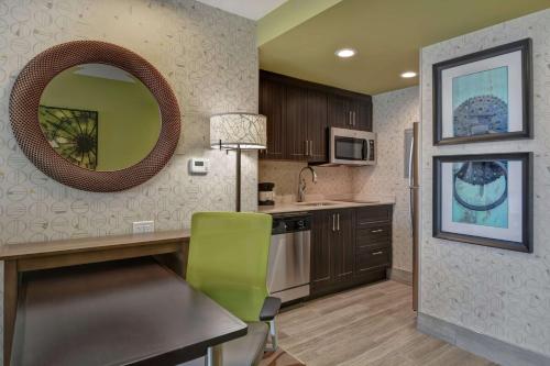 a kitchen with a table and a mirror on the wall at Homewood Suites By Hilton Savannah Airport in Savannah