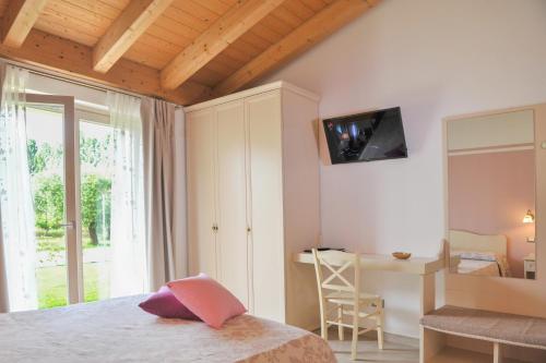 a bedroom with a bed and a desk and a television at Paradiso degli Ulivi B&B in Peschiera del Garda