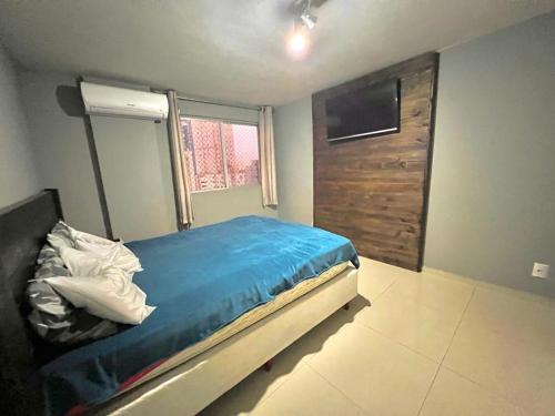 Un dormitorio con una cama azul y una ventana en Apartamento Top, en Balneário Camboriú