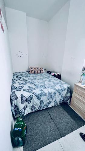 a small bedroom with a bed with a blue comforter at Near Alain Main Bus stop in Mundafinah