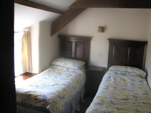 a bedroom with two beds in a room at Barton Cottage in Bude