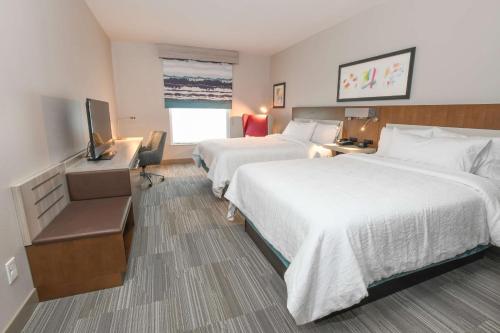 um quarto de hotel com duas camas e uma televisão em Hilton Garden Inn Cincinnati Midtown em Cincinnati