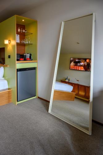 a mirror in a room with a bed and a kitchen at Ohtel Wellington in Wellington