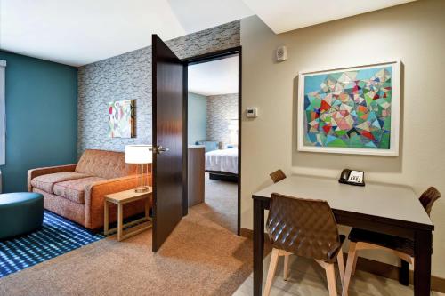 Home2 Suites by Hilton Victorville في فيكتورفيل: غرفة معيشة مع طاولة وأريكة