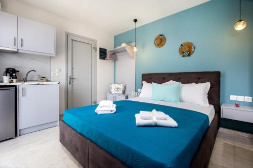 a blue bedroom with a bed with towels on it at Otium Studios in Limenaria