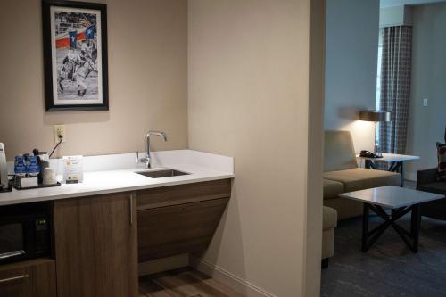 韦科Hilton Garden Inn Waco的带水槽的厨房和客厅