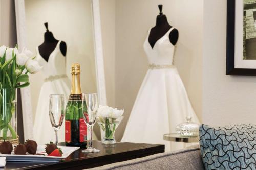 a dress hanging on a wall next to a table with wine glasses at Hotel Ballast Wilmington, Tapestry Collection by Hilton in Wilmington
