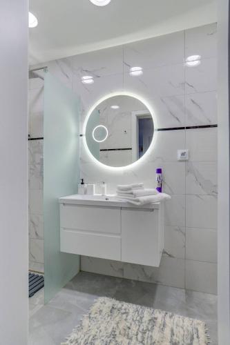 a bathroom with a white sink and a mirror at Wynajem grupowy Szansa in Mrągowo