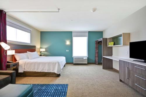 a hotel room with a bed and a flat screen tv at Home2 Suites By Hilton Plymouth Minneapolis in Plymouth