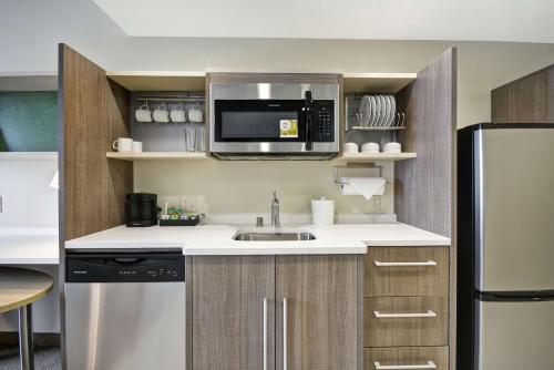 a kitchen with a sink and a microwave at Home2 Suites By Hilton Plymouth Minneapolis in Plymouth