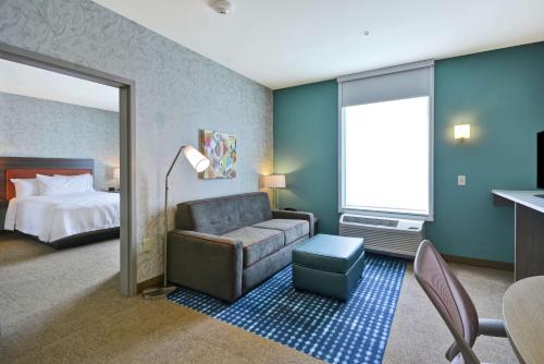 a hotel room with a couch and a bed at Home2 Suites By Hilton Plymouth Minneapolis in Plymouth