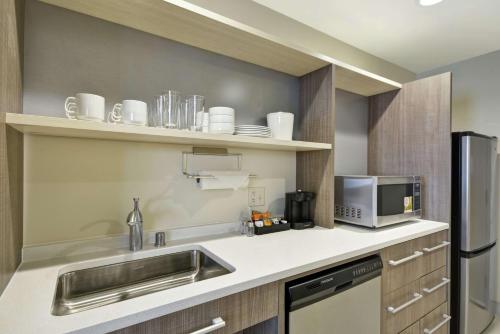 a kitchen with a sink and a microwave at Home2 Suites By Hilton Plymouth Minneapolis in Plymouth