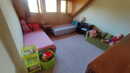 Habitación pequeña con 2 camas y un niño sentado en un sofá en Rigó Nyaralóház, en Lakitelek