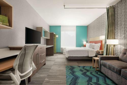 um quarto de hotel com uma cama e um sofá em Home2 Suites By Hilton Columbia Harbison em Columbia