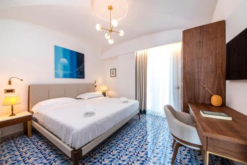 Habitación de hotel con cama grande, escritorio y escritorio. en OraBlu Executive Villas, en Isquia