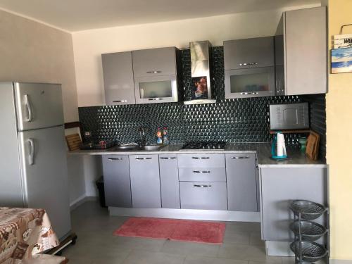 a kitchen with white cabinets and a refrigerator at Villa Karim in Nabeul