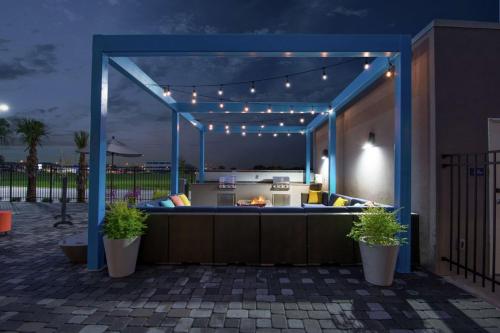 a backyard patio with an outdoor kitchen with lights at Tru by Hilton Lafayette River Ranch in Lafayette