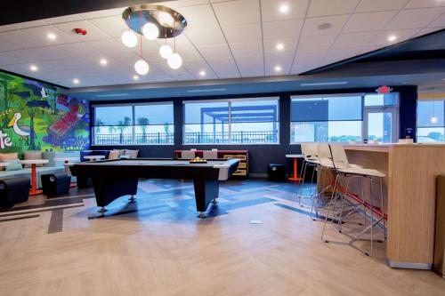 a room with a ping pong table and a bar at Tru by Hilton Lafayette River Ranch in Lafayette