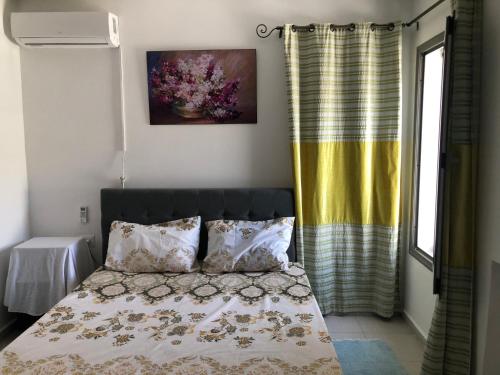 a bedroom with a bed and a yellow curtain at Villa Karim in Nabeul