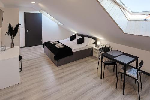 a bedroom with a bed and a table and a window at AURORA JAROSŁAWIEC in Jarosławiec