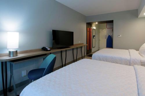 a hotel room with two beds and a television at Tru by Hilton Lafayette River Ranch in Lafayette